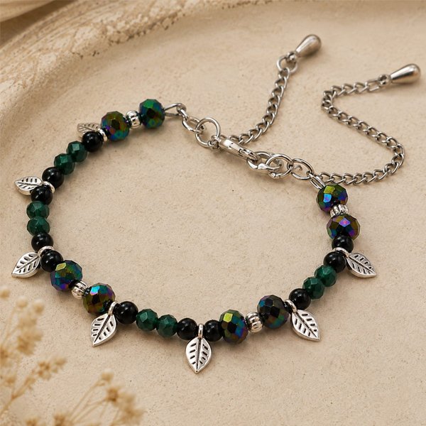 Forest-Whisper-Charm-Anklet Forest Whisper Charm Anklet with emerald green and black faceted beads, iridescent crystal accents, and silver leaf charms on an adjustable chain.