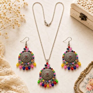 Rainbow Bloom Pendant Set featuring an antique silver finish, colourful enamel accents, multicolour bead detailing, and matching earrings displayed on a light vintage background.