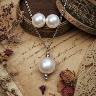 Snowdrop Pearl Pendant Set featuring a white imitation pearl pendant necklace with matching pearl stud earrings in a polished silver-tone finish, displayed on an elegant antique vintage background.