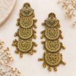 Antique oxidised gold-tone chandelier earrings with intricate floral motifs, layered filigree work, and dangling bead details.