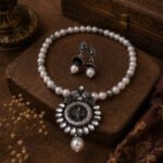 Silver Bloom Pearl Necklace Set featuring an oxidized silver floral pendant with white pearl beads and matching pearl drop earrings.