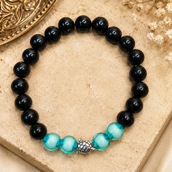 Moonlight Aqua Turtle Bracelet with glossy black beads, translucent aqua beads, and a silver turtle charm.