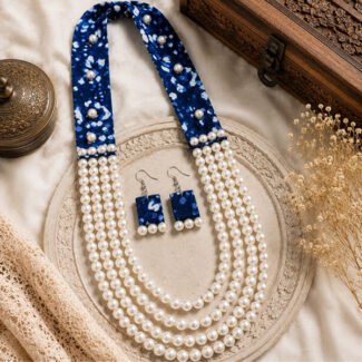 Handcrafted Royal Indigo Layered Pearl Necklace Set featuring indigo printed fabric panels, four layers of white imitation pearls, and matching handmade earrings displayed on a vintage decorative tray.