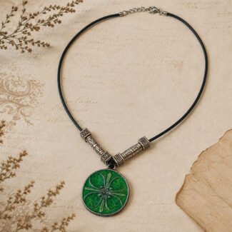 Vintage green glass pendant with an antique silver-toned floral design and black thread necklace.