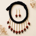 Handmade Rudraksha minimal choker necklace with an original Rudraksha bead, golden chain, and black thread tassel.