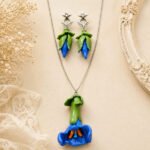 Handmade Bloom Clay Pendant Set inspired by the Aparajita flower, featuring a hand-painted clay flower pendant with a silver chain necklace for elegant everyday wear.