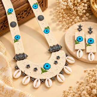 Handmade Blue Blossom Cowrie Cloth Necklace Set featuring embroidered blue floral motifs, oxidised metal accents, cowrie shells, and matching long earrings.