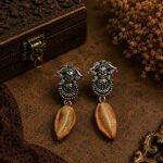 Handmade Durga Cowrie Clay Earrings featuring hand-sculpted clay cowrie shells with oxidised Durga stud earrings. Lightweight, artistic, and elegant for ethnic and contemporary wear.