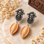 Handmade Durga Cowrie Clay Earrings featuring hand-sculpted clay cowrie shells with oxidised Durga stud earrings. Lightweight, artistic, and elegant for ethnic and contemporary wear.