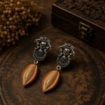 Handmade Durga Cowrie Clay Earrings featuring hand-sculpted clay cowrie shells with oxidised Durga stud earrings. Lightweight, artistic, and elegant for ethnic and contemporary wear.