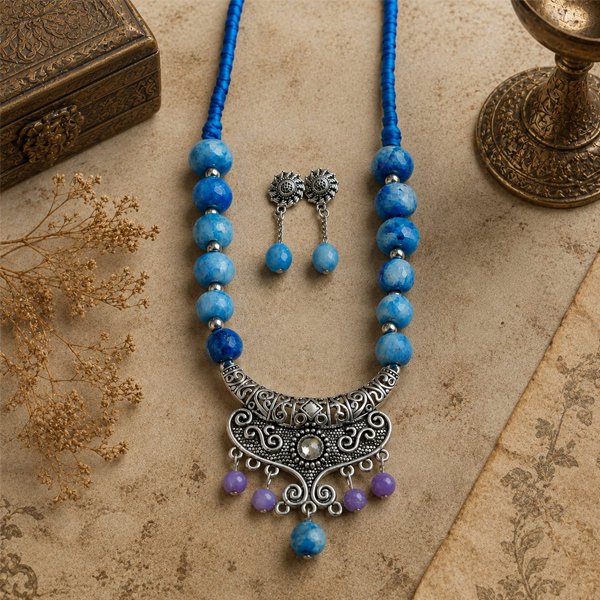 Indigo-Clay-Beaded-Necklace-Set Handmade Indigo Clay Beaded Necklace Set with hand-painted blue clay beads, handcrafted tassels, an oxidized statement pendant, and matching earrings.