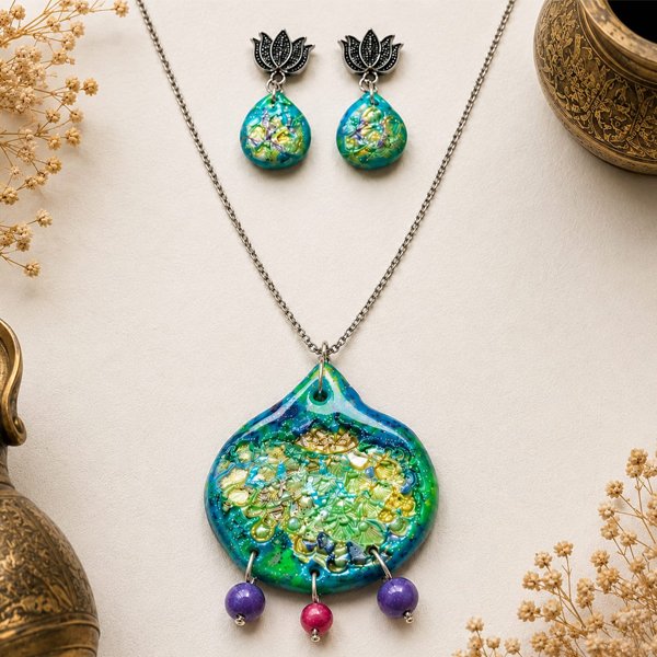 Handmade Peacock Feathers clay pendant set with blue, green, and golden peacock-inspired details, matching earrings, clay beads, and silver chain.