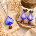 Handmade Twilight Petal Clay Pendant Set with hand-sculpted clay petals, Rudraksha bead, silver-plated chain, lotus earrings, and a glossy blue-purple finish.