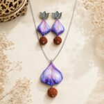 Handmade Twilight Petal Clay Pendant Set with hand-sculpted clay petals, Rudraksha bead, silver-plated chain, lotus earrings, and a glossy blue-purple finish.